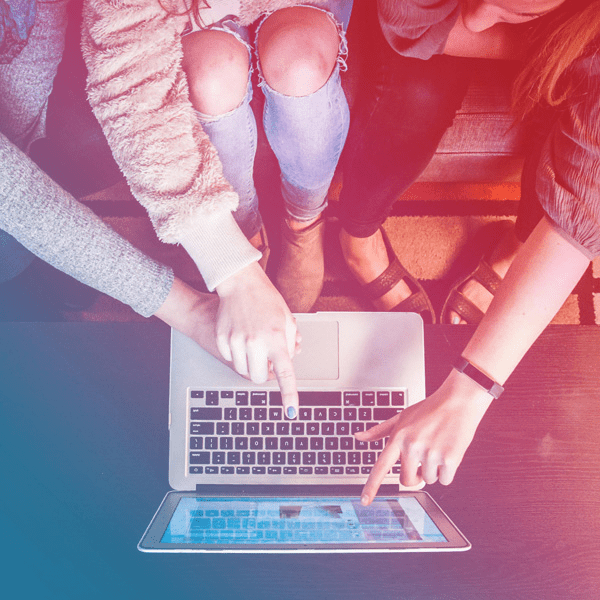 Fugleperspektiv av tre personer som analyserer data på laptop